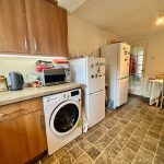 Cosy kitchen with appliances and dining table.