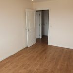 Empty room with wooden floor and open door.
