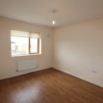 Empty room with wooden floor and window light.