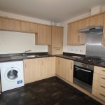 Modern kitchen with wooden cabinets and appliances.