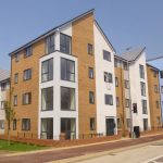 Modern residential building with brick and white facade.