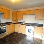 Modern kitchen with wooden cabinets and appliances.