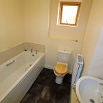 Small bathroom with bathtub, toilet, and sink.