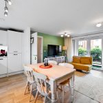 Modern open plan kitchen and living room, bright decor.