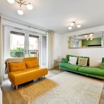 Modern living room with green and yellow sofas.