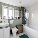 Modern bathroom with sink, toilet, and bathtub.