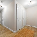 Corridor with wooden flooring and white doors