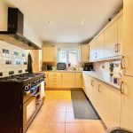 Modern kitchen with wooden cabinets and black cooker.