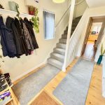 Modern hallway with coats and staircase.