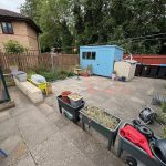 Back garden with shed and garden tools.