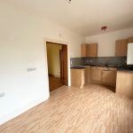 Modern kitchen with wooden cabinets and flooring.