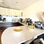 Modern kitchen with white counter and appliances.