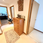 Hallway with dresser and open doors