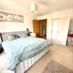 Bright bedroom with bed, wardrobe, and decor.