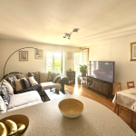 Modern living room with large TV and sofa.