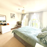 Bright bedroom with double bed and balcony view.