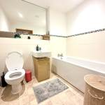 Modern white bathroom with toilet and bathtub.