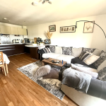 Spacious living room with modern kitchen and cosy sofa.