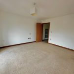 Spacious empty room with carpet and door