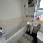 Modern bathroom with bath, sink, and toilet.