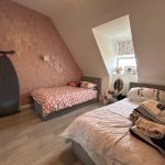 Small bedroom with two single beds and window.