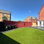 Modern garden with artificial grass and brick houses.