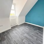 Small attic room with blue accent wall.