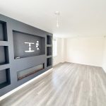 Spacious room with modern grey accent wall.