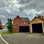 Cloudy day over red brick houses and garage