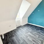Empty room with blue accent wall and window