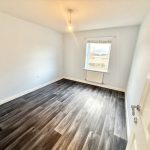 Empty room with dark wood flooring.