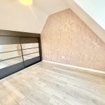Empty attic room with mirrored sliding doors.