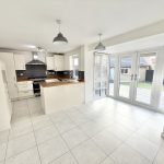 Modern kitchen with white cabinets and patio doors.