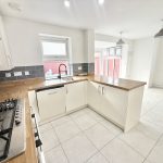 Modern kitchen with wooden countertops and tiled floor.
