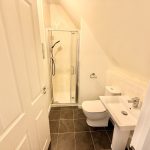 Modern bathroom with shower, toilet, sink.