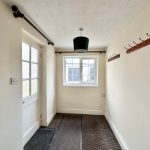 Empty hallway with hooks and window