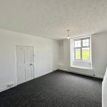 Empty bright room with window and white walls
