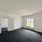 Bright empty room with window and open door.