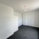 Small empty white room with grey carpet.