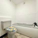 Modern white bathroom with toilet and bathtub.