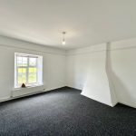 Empty room with window and light fixture.