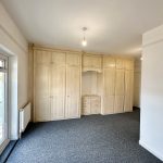 Spacious room with fitted wardrobes and carpet.