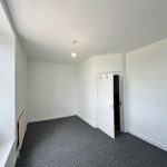 Empty room with white walls and open door.