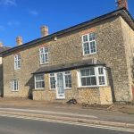 Stone house with 'To Let' sign.