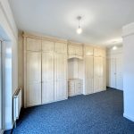 Spacious bedroom with fitted wardrobes and carpet flooring.
