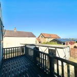 View from balcony, countryside houses and clear sky.