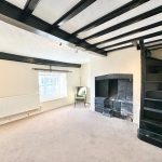 Cosy room with fireplace and dark wood beams.