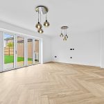 Bright empty room with wooden floor and glass doors.