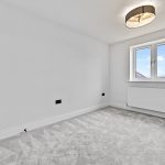 Empty white room with window and ceiling light.