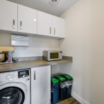 Utility room with washing machine and appliances.
